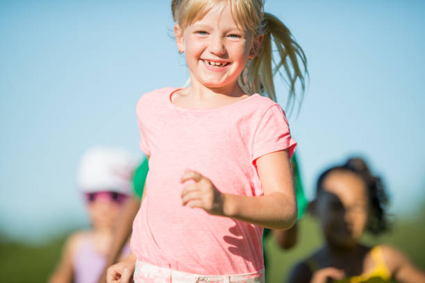 istock Smiling little girl running outdoors at a park 1310664503