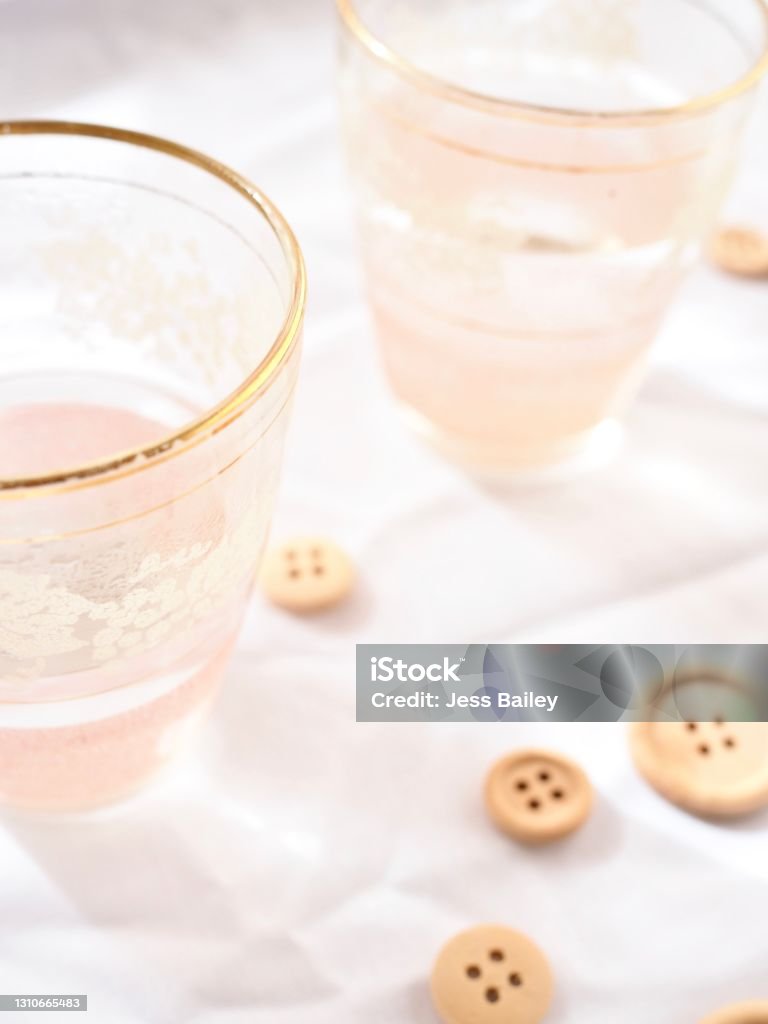 Pink glasses and buttons Bright and light photo of pink glass on a white background Australia Stock Photo