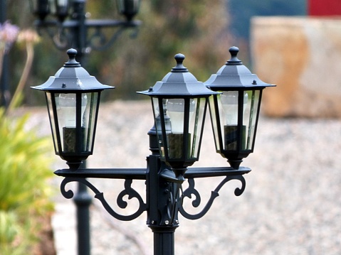 Close up of a line of lamps at one side of an old blurred house.