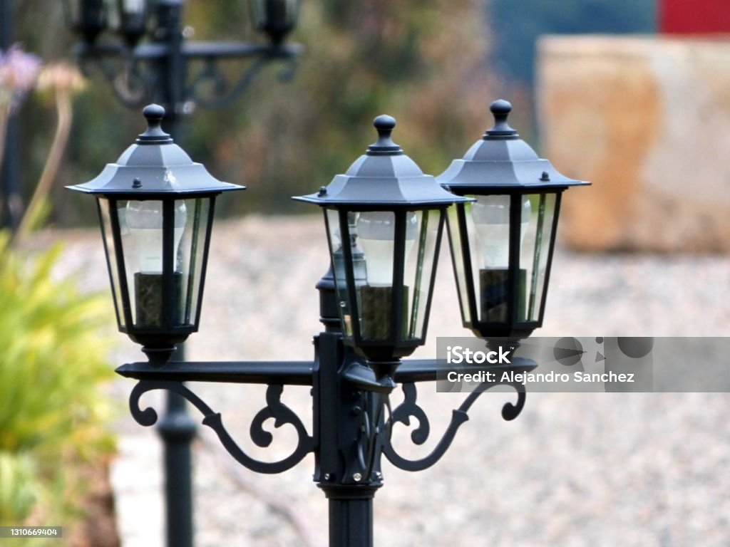 Line of antique lamps besides the house Close up of a line of lamps at one side of an old blurred house. Antique Stock Photo