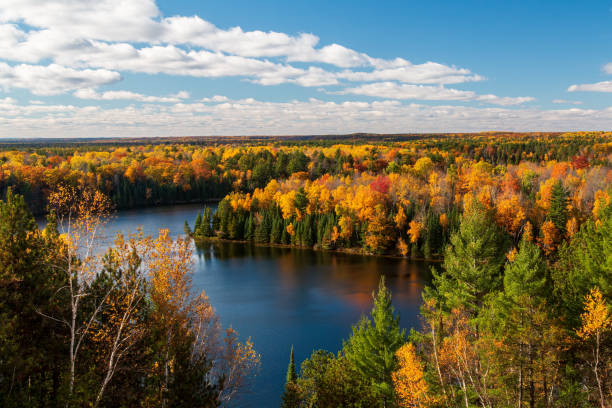 vista soleada de las riberas altas durante el otoño sobre el estanque de la presa de cooke del río ausable - michigan fotografías e imágenes de stock