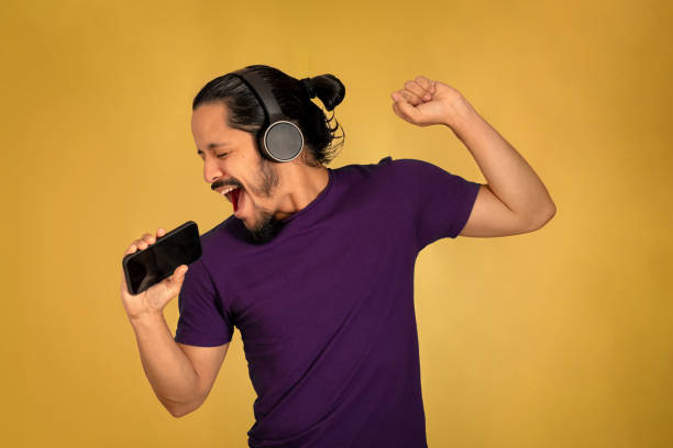 istock Young man portrait singing with yellow background 1310678454