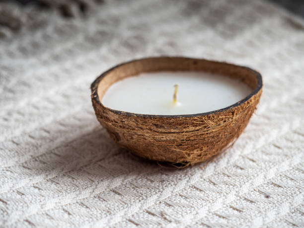 istock Decorative candle in a coconut on a white knitted blanket 1310683778