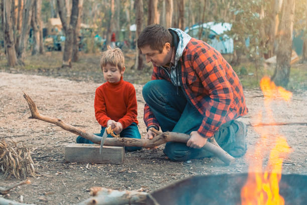 istock Father and son cutting a log in the forest 1310687169