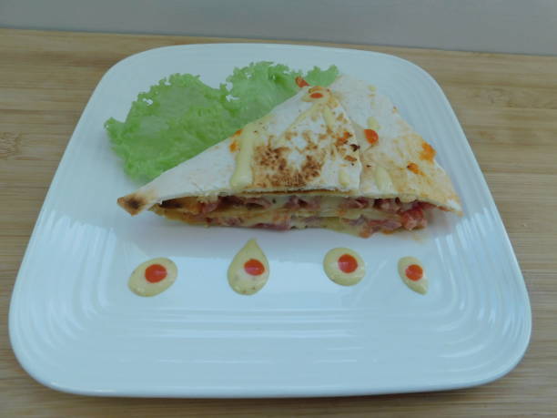 istock quesadillas Mexican fast food. flatbread stuffed with vegetables, served on a white plate 1310689429