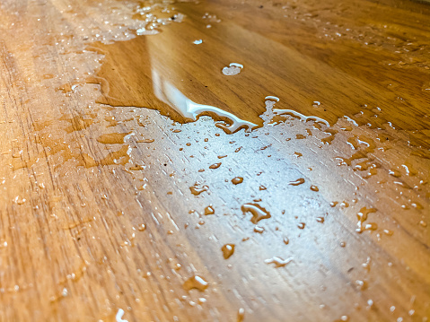 water spill on parquet wood floor, which leaking from air conditioner in the house.