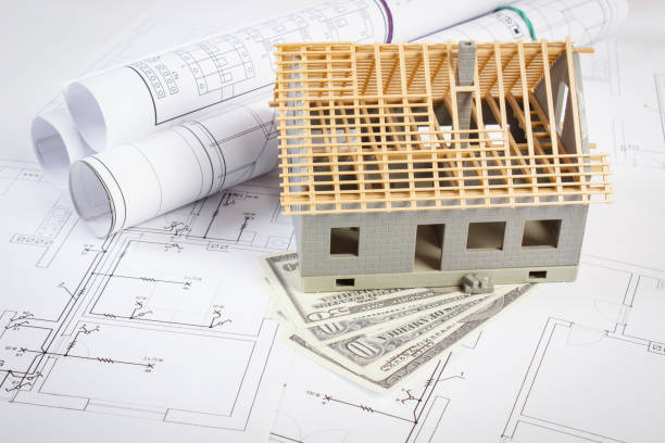 istock House under construction and currencies dollar on electrical drawings and diagrams for project, building home cost concept 1310690825