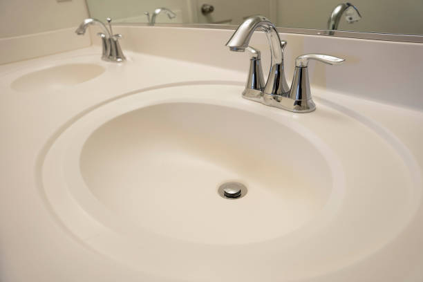 istock Close up on white double bathroom sinks with chrome faucets. 1310693516