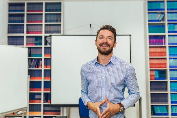 istock Smiling male coach giving presentation for audience in lecture hall 1310697667