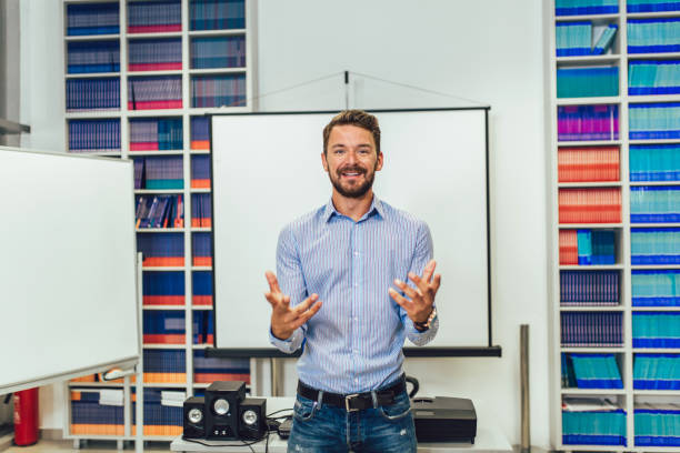 istock Smiling male coach giving presentation for audience in lecture hall 1310698243