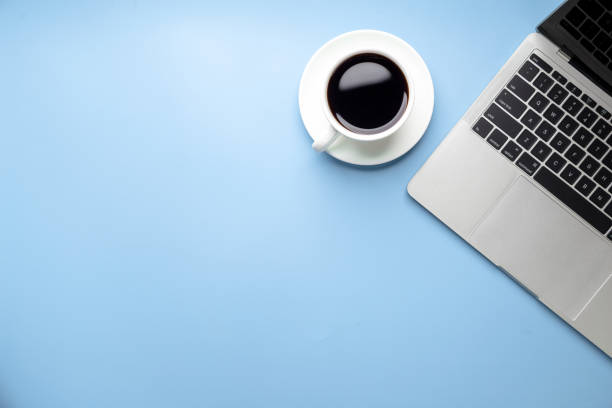 istock Flat lay, top view office table desk. Workspace with, laptop,office supplies, pencil, green leaf, and coffee cup on blue background. 1310702364