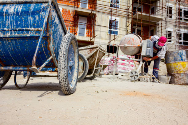 robotnicy wylewają beton z betoniarki do taczki - scaffolding wheel construction site metal zdjęcia i obrazy z banku zdjęć