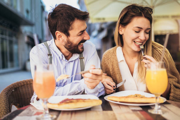 istock Young couple sitting in a restaurant eating pizza 1310707169