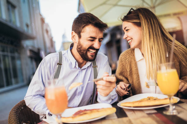 istock Young couple sitting in a restaurant eating pizza 1310707470