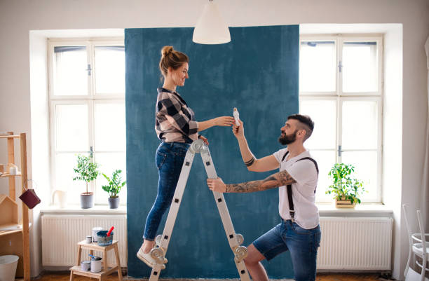 istock Mid adults couple changing light bulb indoors at home, relocation and diy concept. 1310708162