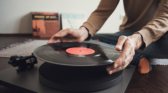 Man holding LP record, having fun at home. Enjoy life, have fun, lifestyle, leisure, music, hobby, lockdown, technology concept