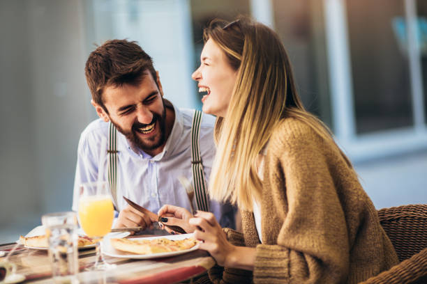 istock Young couple sitting in a restaurant eating pizza 1310709243