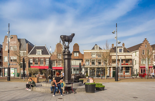 People sitting at the cow sculpture on the Koemarkt square in Purmerend, Netherlands
