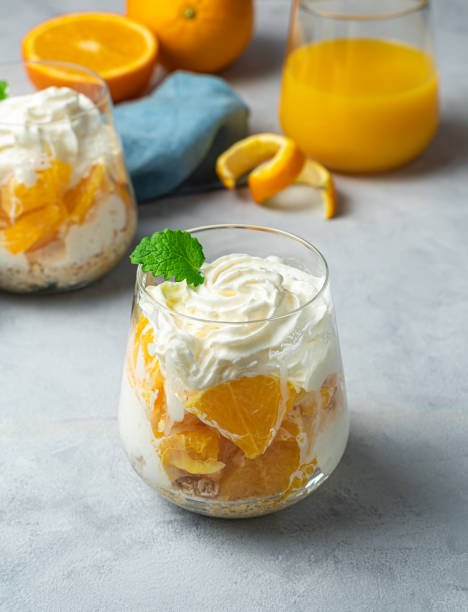 istock Fruit dessert with orange, cream and cereal. Vertical view 1310712958