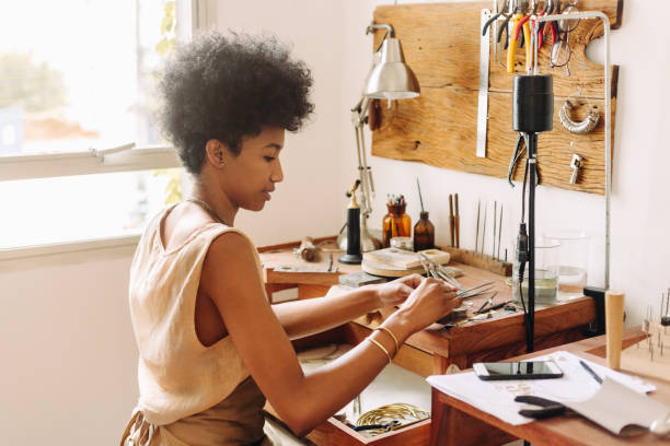 mujer haciendo joyas hechas a mano en su taller - hacer fotografías e imágenes de stock