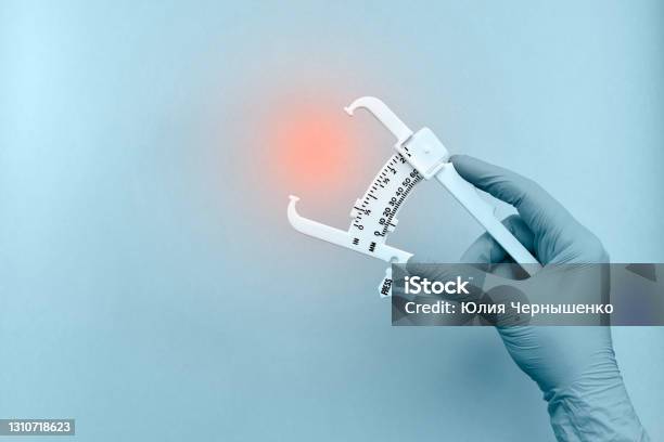Hand With A Device For Measuring Subcutaneous Fat Stock Photo - Download Image Now - Overweight, Caliper, Prevention