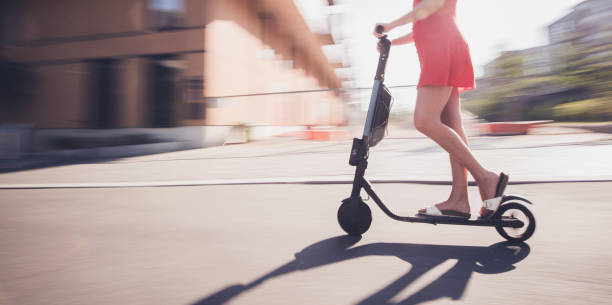istock Side view of unrecognizable female on electric scooter 1310722368