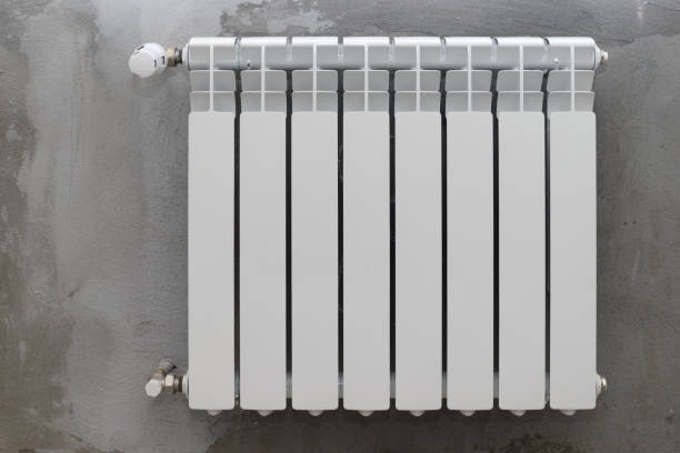 istock White radiator on a gray rough wall 1310722370