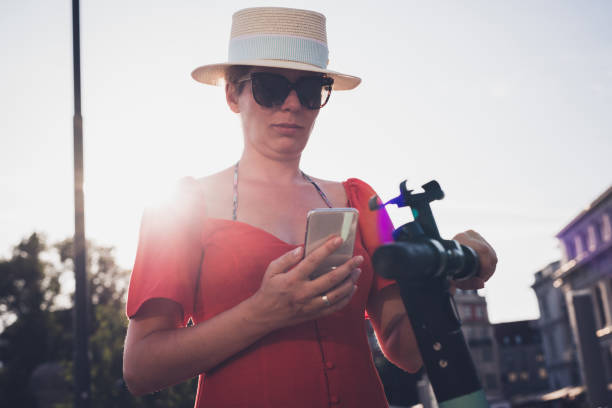 istock Woman using smartphone and renting modern electric scooter with an application 1310722464
