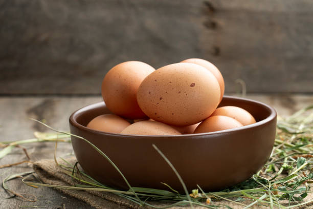 istock Fresh chicken eggs in a clay bowl on the hay. 1310723421