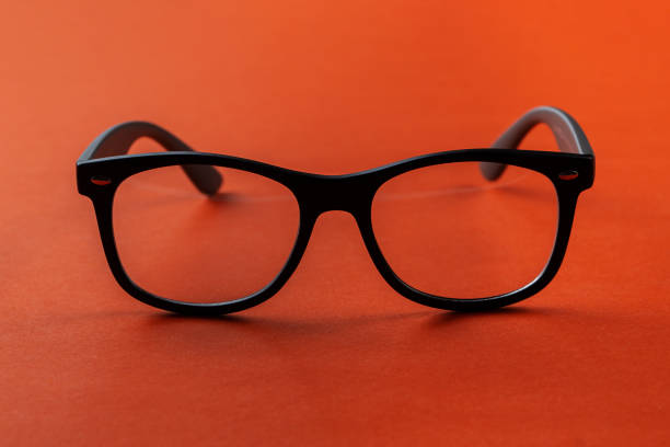 Eyeglasses on orange background, myopia or presbyopia.  Eyesight correction. Fashion accessories.