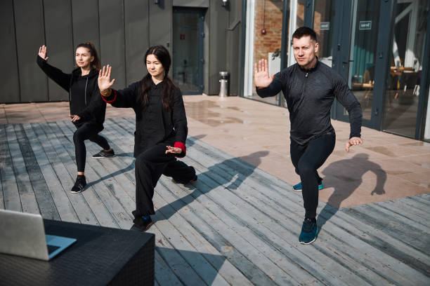 istock Kung fu group practice outside with laptop images 1310727254