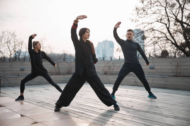 istock Tai chi teacher with students working out on the roof 1310727330