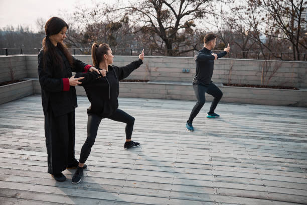 istock Watchful kung fu teacher making corrections to student pose 1310727360