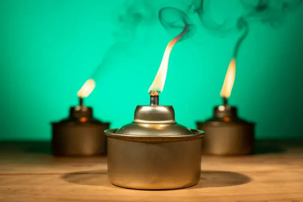 Photo of Pelita or oil lamp, traditional Malay oil lamp lit up with smoke during Ramadan and Hari Raya Aidilfitri Muslim celebration