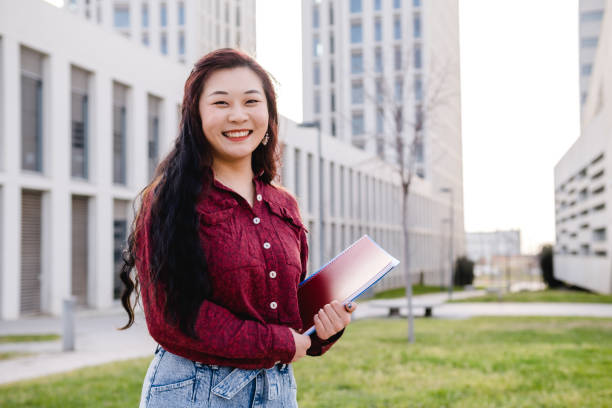 istock Young woman asian student looking at camera at university campus. Copy space 1310735795