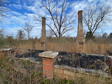 Two brick chimneys by old house foundation