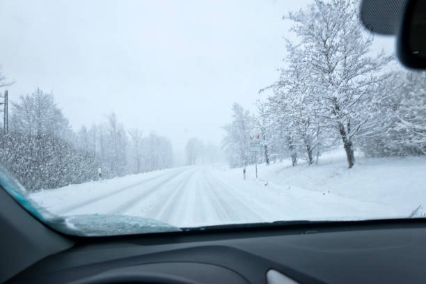 istock Driving on an empty country road during heavy snowfall 1310737201