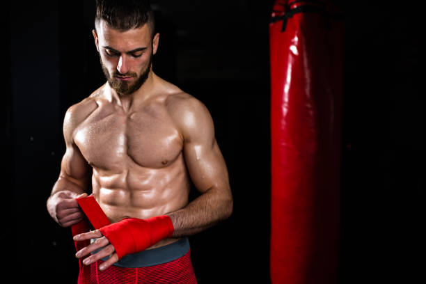 istock A handsome young man getting ready for boxing in a dark gym 1310740513