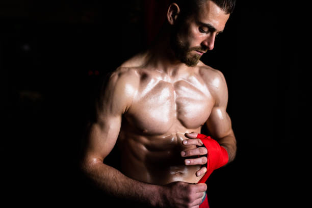 istock A boxer wrapping his hand in the dark 1310740537