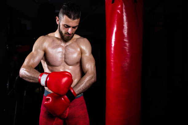 istock A handsome boxer putting on boxing gloves 1310740558
