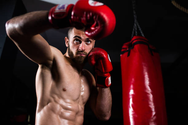 istock A boxer throwing a hook in a dark gym 1310740576
