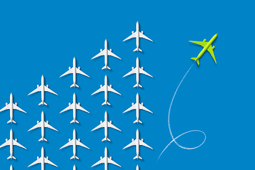 A swarm of passenger planes from which a green one separates itself