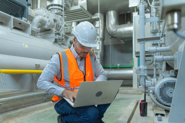 istock An engineer man or worker, people using a laptop computer, working in industry factory. Chiller tower or cooling tower in building. System work machine. Condenser Water Supply pipe lines. Ventilation. 1310743536