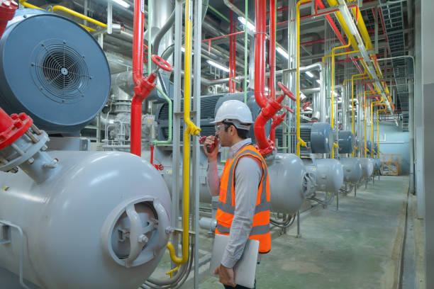 istock An engineer man or worker, people working in industry factory. Chiller tower or cooling tower in building. System work machine. Condenser Water Supply and return pipe lines. Ventilation compressor. 1310743574