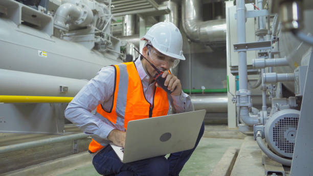 istock An engineer man or worker, people using a laptop computer, working in industry factory. Chiller tower or cooling tower in building. System work machine. Condenser Water Supply pipe lines. Ventilation. 1310743575