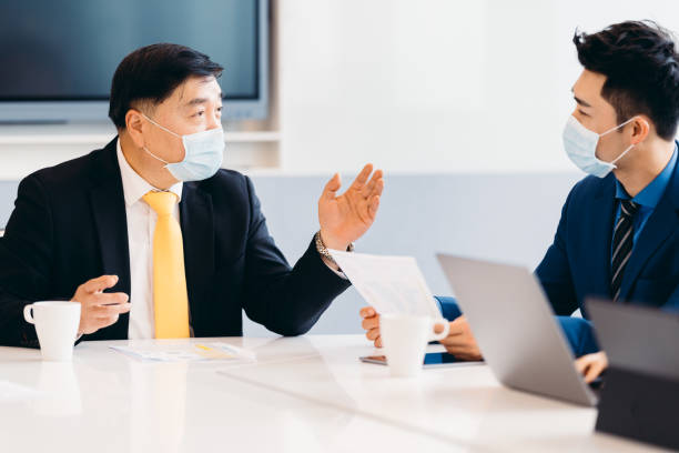 istock Asian business people in discussion in an open working environment. 1310744561