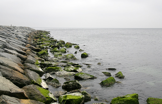 pyramid of stones near the ocean. the sea is in fog