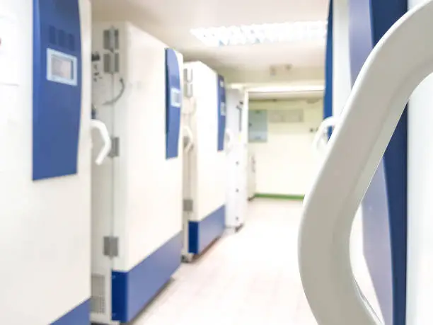 Photo of Blur abstract background of ultra low temperature freezer for specimens storage in laboratory testing in medical hospital.Blurry view rows of refrigerators for lab research in university