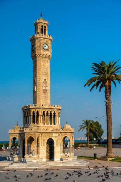 torre storica dell'orologio di smirne, piccioni e palme - izmir turkey konak clock tower foto e immagini stock