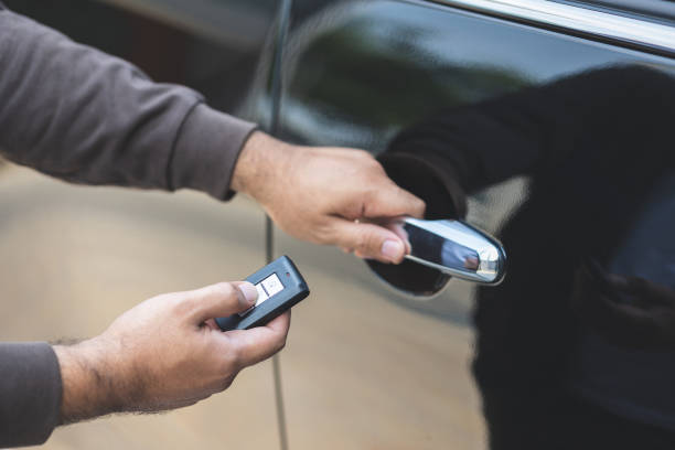 nahaufnahme männliche hand halten autoschlüssel. mann entsperren autotür durch entfernte taste drücken in der nähe von auto-tür. - car door push button lock car stock-fotos und bilder